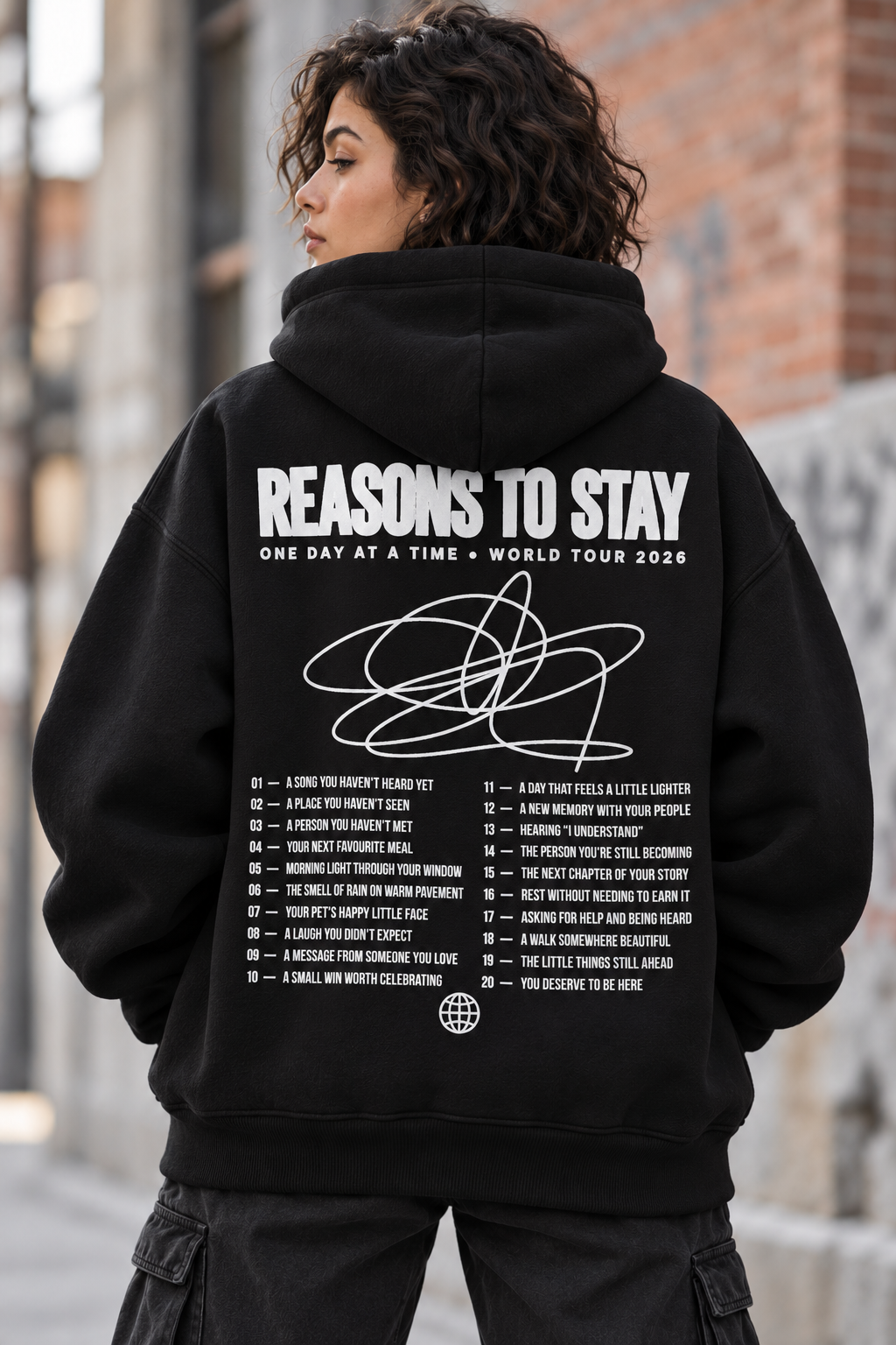 Deluxe oversized black hoodie, back view with white Reasons to Stay World Tour 2026 print and 20 reasons list