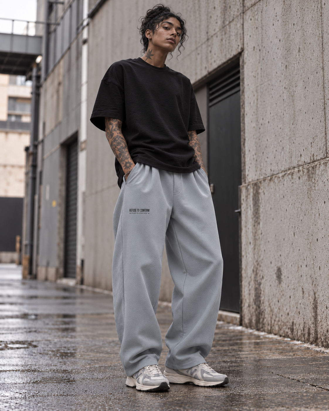 Brown-skinned tattooed model wearing slate grey Refuse to Conform barrel joggers